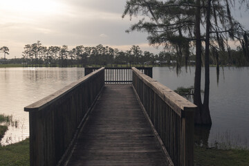 An old wooden pier looking over a lake on a warm afternoon.
