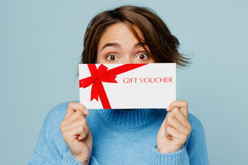 Close up young happy surprised shocked woman wear knitted sweater holding covering mouth with gift...