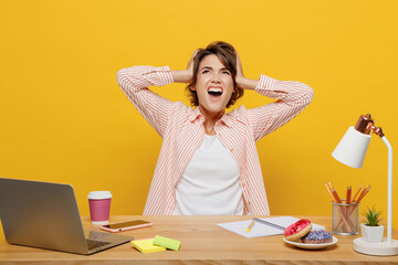 Young employee business woman in casual shirt sit work at office desk with pc laptop cover ear with...