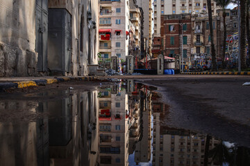 Naklejka premium Street view with water reflection after rain. Summer Rain Showers, urban view.