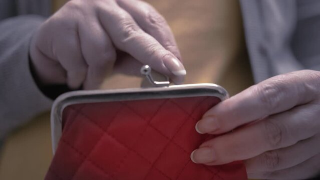close up of woman hands counts pennies and puts them in her wallet, economic crisis, electricity bills, static shot