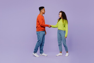 Obraz premium Full body young couple friends family man woman of African American ethnicity wear casual clothes together hold hands folded handshake gesture isolated on plain purple background Friendship concept.
