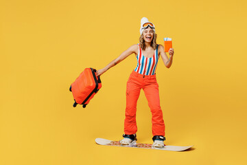 Snowboarder woman wear orange ski suit goggles mask hat swimsuit spend extreme weekend hold...
