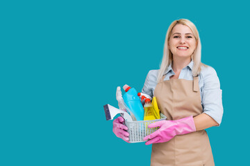Photo of caucasian pretty housemaid wearing rubber gloves for hands protection holding bucket with cleaning supplies isolated over blue background