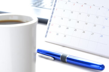 カレンダーとコーヒーのマグカップのイメージ