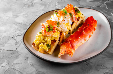 baked brioche, scrambled eggs, and crab meat on plate