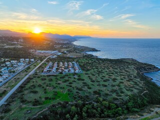 Sunset with green field which is land for real estate in Esentepe, North Cyprus