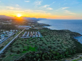 Gordijnen Sunset with green field which is land for real estate in Esentepe, North Cyprus © Alp Galip