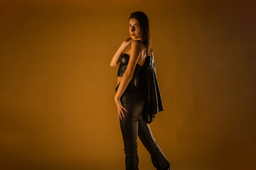 Fototapeta na wymiar Fashion girl in studio. Black leather outfit