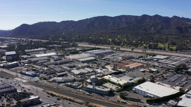 Wide aerial panning shot across the 5 Freeway alongside Griffith Park in Glendale, California. 4K