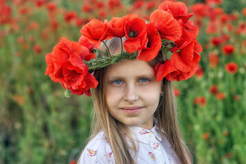 Portrait of a beautiful young girl in a wreath of red poppies in nature - 552272934