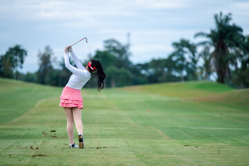 	
Professional woman golfer teeing golf in golf tournament competition at golf course for winner.	

