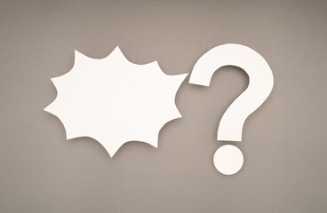 White comic speech bubble and a white question mark on a gray background