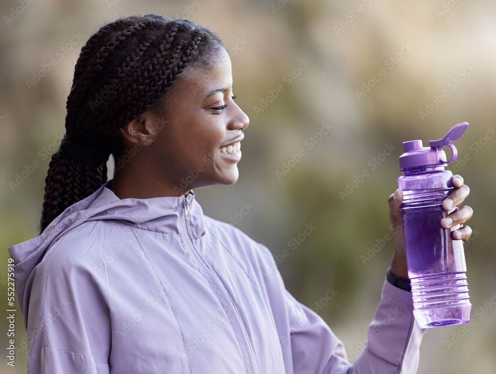 Wall mural Water bottle, sports and black woman in park for outdoor nutrition, wellness and fitness gear or plastic product on blurred background. Workout athlete or runner exercise for purple fashion in nature