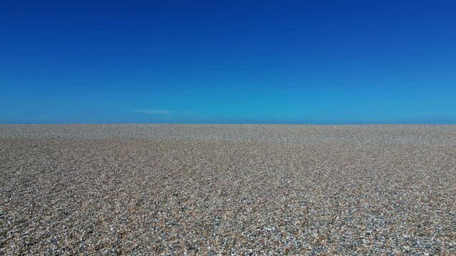 Aerial abstract view of pebbled beach and clear sky introducing a blue sea at Weybourne, Norfolk, UK.