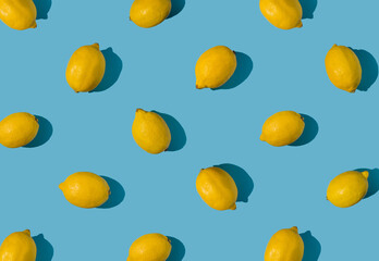 Summer pattern made with fresh yellow whole lemons on vibrant light blue background. Minimal background summer concept on bright sunlight with sharp shadows - 552278374