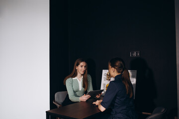 Consultation in cosmetology clinic. Female professional beauty doctor talking with pretty young female.