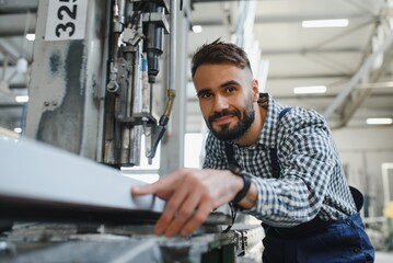 Happy Professional Heavy Industry Engineer Worker Wearing Uniform, and Hard Hat in a Steel Factory. Smiling Industrial Specialist Standing in a Metal Construction Manufacture