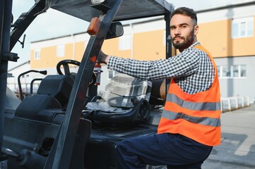 Fototapeta na wymiar Waving forklift driver in the warehouse of a haulage company while driving forklift