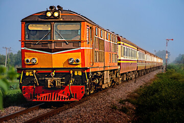 Naklejka premium Passenger train by diesel locomotive on the railway.