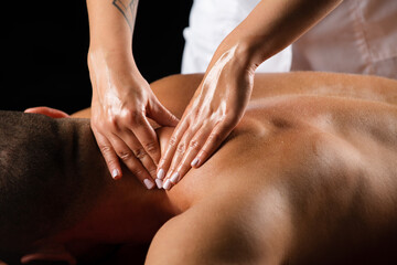 Massage for man. Physiotherapist massaging male shoulder. - obrazy, fototapety, plakaty