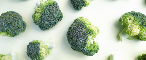 Broccoli inflorescences close-up, green fresh cabbage, Pattern of broccoli inflorescences on a yellow background, banner