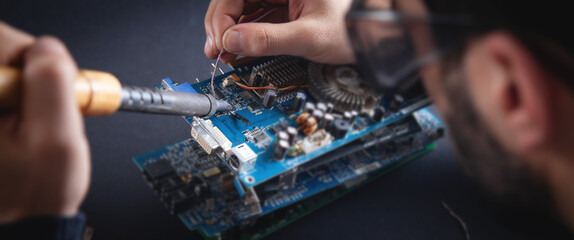 Fototapeta Computer hardware engineering. Engineer soldering computer motherboard obraz