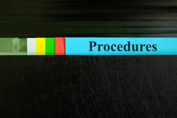 Hand picking procedures file record in black binder folder. Work procedure concept.
