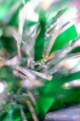 Macro of greenery tinsel in the foreground. Festive carnival and christmas background