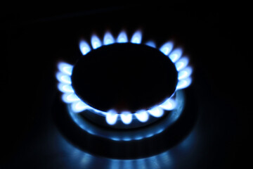 Top view of a burning gas burner with blue gas on a dark background	