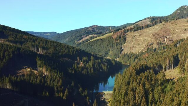 Rising aerial over Olt River tributary in scenic Hasmas Mountains, Romania