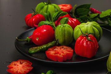 Green and red ribbed tomatoes, American or Florentine variety. Ripe vegetables, fresh bay leaves