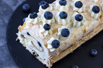Top view of the delicious meringue roll. Protein dessert with blueberries
