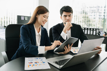 Female discussing new project with male colleague. Mature woman talking with young man in office.