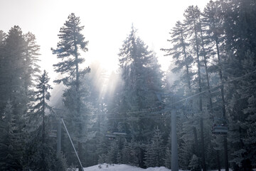 Fog in the winter forest. Chair lift in the ski resort of Bansko, Bulgaria. Winter landscape in the...