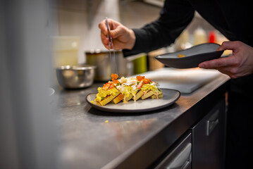 chef cooking brioche with scrambled eggs, caviar and crab meat on kitchen