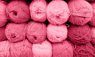 Yarn Balls Wool in a Fabric Shop. Background from colored acrylic yarn. Skeins of thread close-up. Materials for needlework, for knitting and crocheting. Color Of The Year 2023 - Viva Magenta