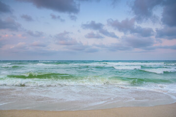 velvet season seascape. waves rushing on the beach. cloudy sky before the evening storm