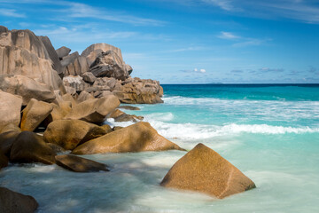 Big granite rocks on the Grand Anse beach. La Digue island, Seychelles. Tropical landscape with sunny sky.
