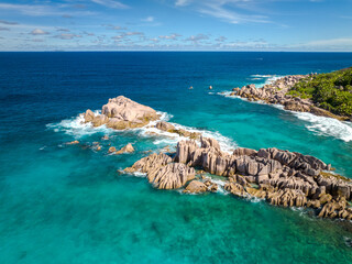 Waves crashing on rock cliff. Famous Grand Anse beach on the La Digue island, Seychelles