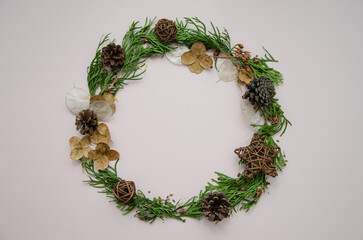 Christmas and new year festive round frame, card template with dried flowers, thuja branches, thuja buds and fir cones, flat lay, top view