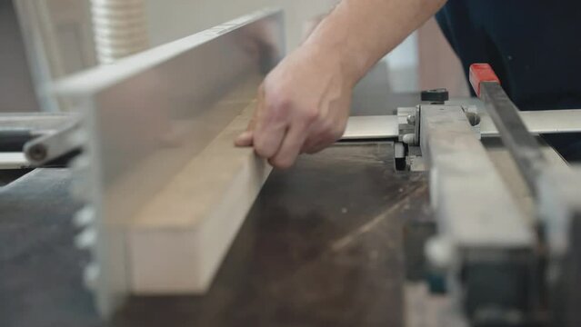 Process of sanding wood plank surface on workbench with special grinding machine, wood worker polishing thin timber in workshop, preparation of wood planks for high quality furnitures production