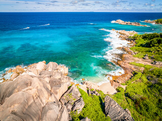 Aerial view Top down seashore. Waves crashing on rock cliff. Beautiful dark sea surface in sunny day summer background Amazing seascape top view seacoast at La Dique Grand l'Anse, Seychelles