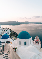 View at sunrise the famous blue domes and Aegean ocean in Oia, Santorini. The domes are from the...