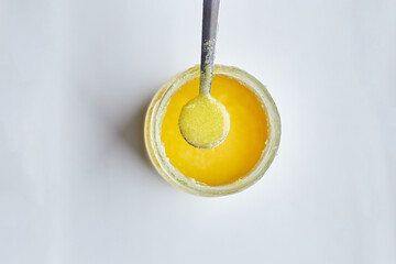 Ghee oil or clarified butter in jar, clarified liquid butter on white background, close up