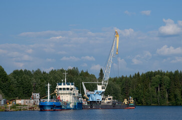 Fototapeta premium Cargo ships in the bay on a bright sunny day. Blue water and sky