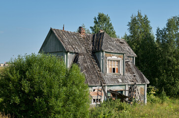 Fototapeta na wymiar View of an old abandoned dilapidated wooden house