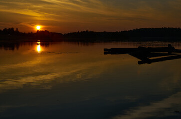 Sunrise in the cloudy sky over the water surface