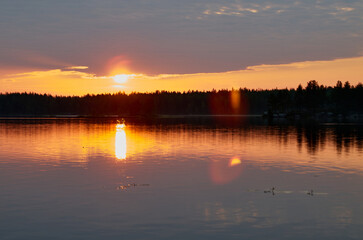 Sunrise in the cloudy sky over the water surface