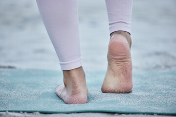 Woman in yoga stretching feet at a beach training legs in a holistic foot exercise or workout in nature. Fitness, wellness or spiritual zen girl exercising for balance or healthy strong body alone